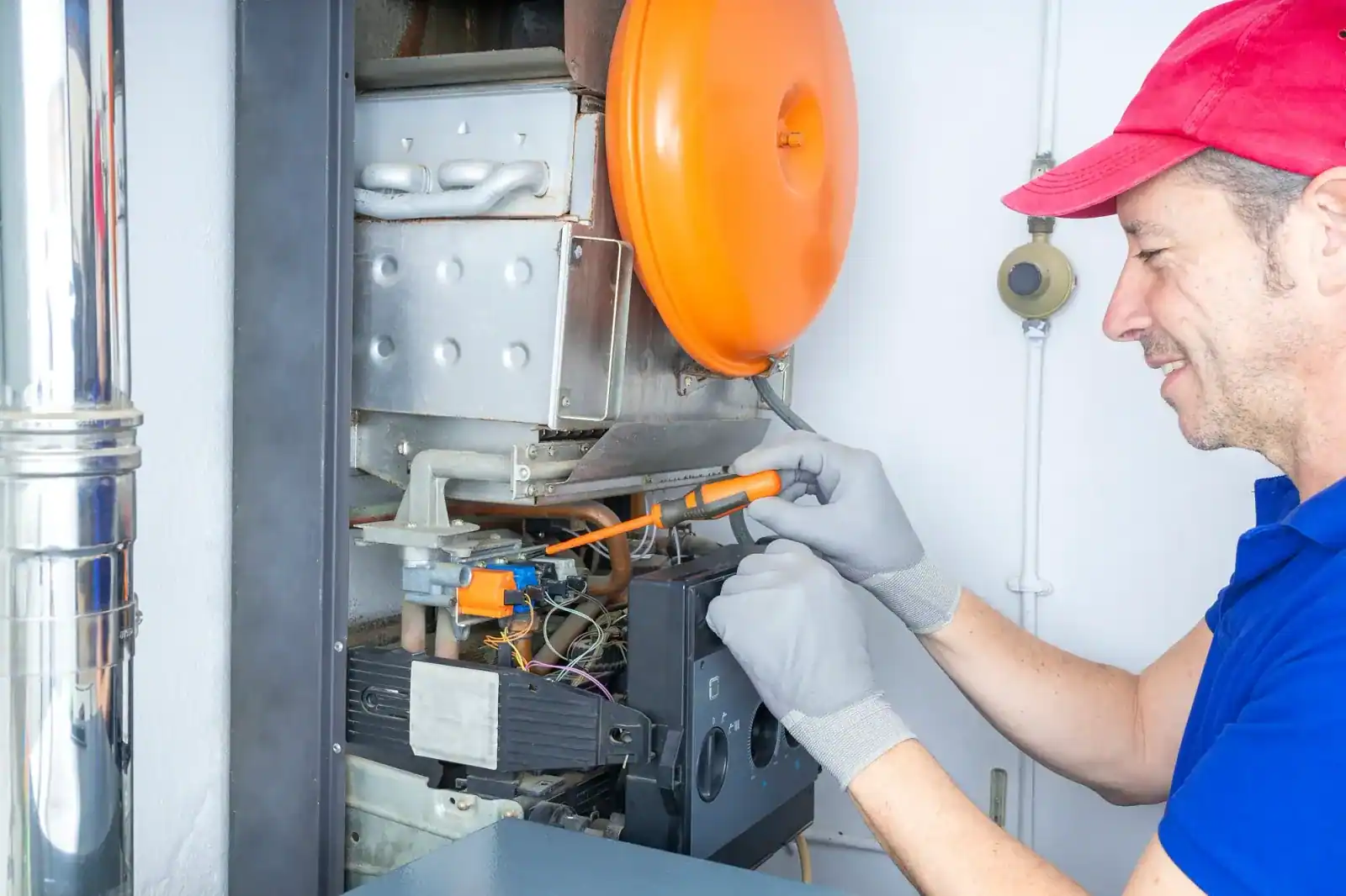 Techniker arbeitet an einer geöffneten Gastherme