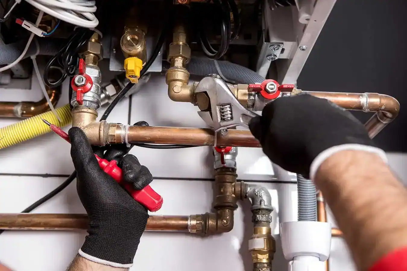 Installateur montiert die Anschlüsse einer neuen Gastherme